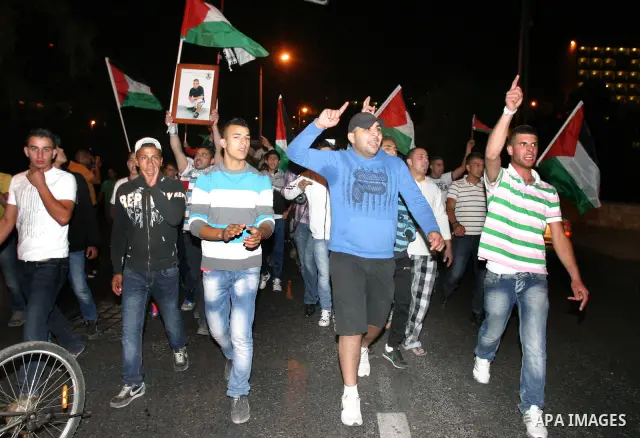 Palestinian hold national flags during celebrate after the signing of a deal to end the prisoners hunger strike in Jerusalem on 14 May 2012. Israel and Palestinian signed an agreement 14 May ending a mass hunger strike b...