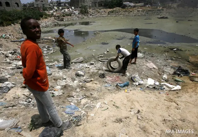 Palestinian boys stand among the garbage in the Rafah Refugee Camp in the southern Gaza Strip, ahead of Nakba Day. on May 15, 2012. 'Nakba' Day for the Palestinians is an annual day of commemoration of the displacement t...