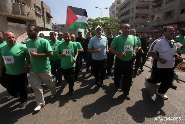 The head of Gaza's Hamas government, Ismail Haniya (blue polo shirt), takes part in a marathonin Gaza on May 15, 2012. 'Nakba' Day for the Palestinians is an annual day of commemoration of the displacement that followed...