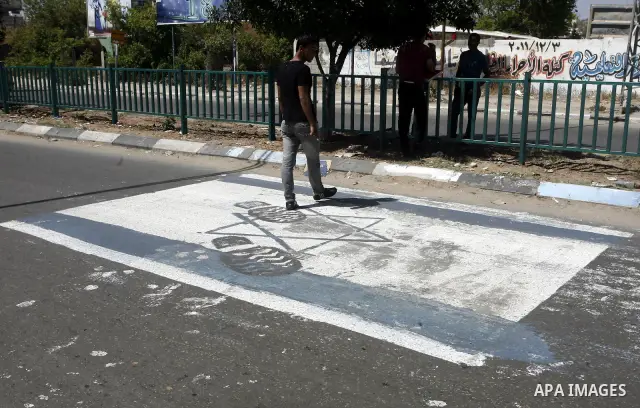 A Palestinian man walks on Israeli flag which painted by Palestinian artist paint marking Nakba in Gaza City May 15, 2012. Palestinians mark Nakba, or catastrophe, of Israel's founding in a 1948 war, when hundreds of tho...