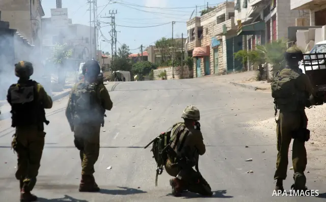 Israeli soldiers fire teargas, towards Palestinian stone throwers deployed at the entrance of the al-Aroub Palestinian refugee camp, just north the West Bank town of Hebron on May 15, 2012, as Palestinians mark Nakba day...