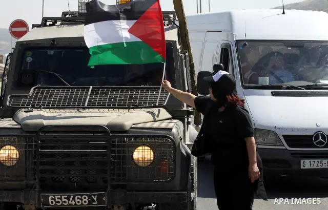 Israeli soldiers stand face to Palestinian and foreign activists who hold Palestinian flags during a demonstration marking the 64th anniversary of the 'Nakba' ('catastrophe'), at the Hawara checkpoint near the West Bank...