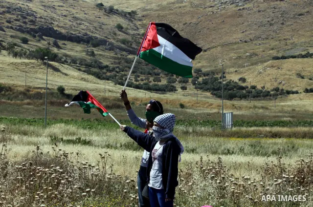A masked Palestinian demonstrator waves a national flag during a demonstration marking the 64th anniversary of the 'Nakba' ('catastrophe'), at the Hawara checkpoint near the West Bank city of Nablus, 15 May 2012. Thousan...