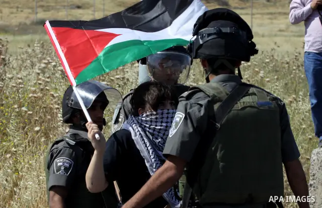 Israeli soldiers stand face to Palestinian and foreign activists who hold Palestinian flags during a demonstration marking the 64th anniversary of the 'Nakba' ('catastrophe'), at the Hawara checkpoint near the West Bank...
