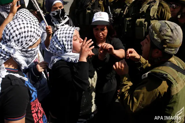 Israeli soldiers stand face to Palestinian and foreign activists who hold Palestinian flags during a demonstration marking the 64th anniversary of the 'Nakba' ('catastrophe'), at the Hawara checkpoint near the West Bank...