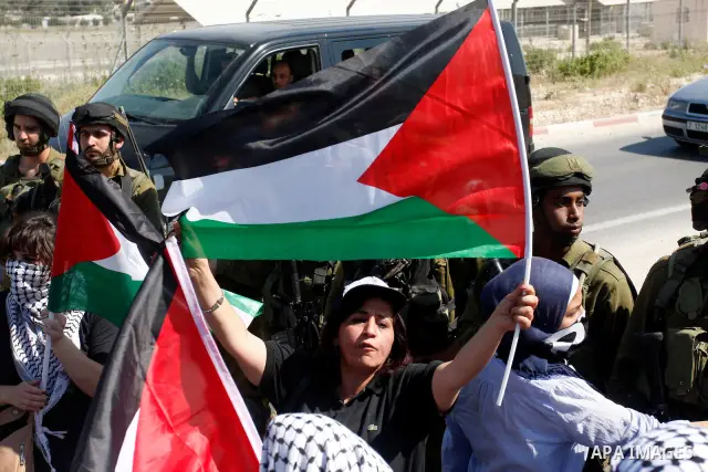 Israeli soldiers stand face to Palestinian and foreign activists who hold Palestinian flags during a demonstration marking the 64th anniversary of the 'Nakba' ('catastrophe'), at the Hawara checkpoint near the West Bank...