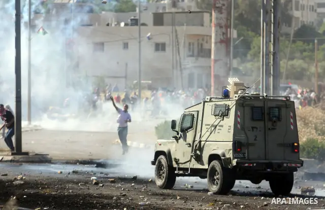 Palestinian protesters throw stones towards Israeli border police during clashes on Nakba Day near Ofer prison, near Ramallah, the West Bank, 15 May 2012. Thousands marched in the West Bank and Gaza Strip, commemorating...