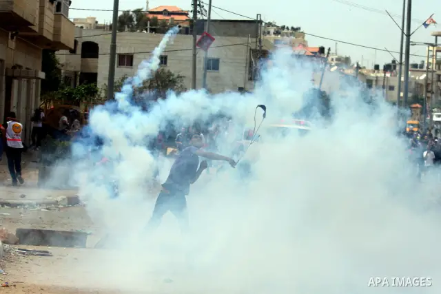 Palestinian stone throwers try to avoid tear gas fired by Israeli soldiers, during clashes on Nakba Day near Ofer prison, near Ramallah, the West Bank, 15 May 2012. Thousands marched in the West Bank and Gaza Strip, comm...