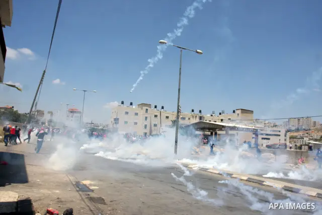 Palestinian stone throwers try to avoid tear gas fired by Israeli soldiers, during clashes on Nakba Day near Ofer prison, near Ramallah, the West Bank, 15 May 2012. Thousands marched in the West Bank and Gaza Strip, comm...