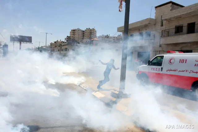 Palestinian stone throwers try to avoid tear gas fired by Israeli soldiers, during clashes on Nakba Day near Ofer prison, near Ramallah, the West Bank, 15 May 2012. Thousands marched in the West Bank and Gaza Strip, comm...