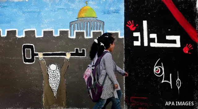 School girls walk past newly painted mural on the 64th anniversary of "Nakba", Arabic for catastrophe, the term used to mark the events leading to Israel's founding in 1948, in Gaza City, Tuesday, May 15, 2012. Hundreds...