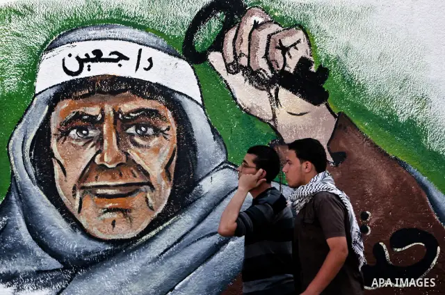 Palesstinians past newly painted mural on the 64th anniversary of "Nakba", Arabic for catastrophe, the term used to mark the events leading to Israel's founding in 1948, in Gaza City, Tuesday, May 15, 2012. Hundreds of t...