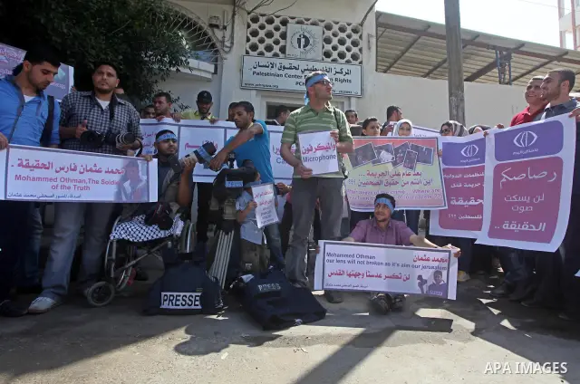 Palestinian journalists and photographers take part in a protest in support with the photographer, Mohammed Osman, in front of Palestinian Centre for Human Rights in Gaza city on May 16, 2012. Photo by Ashraf Amra