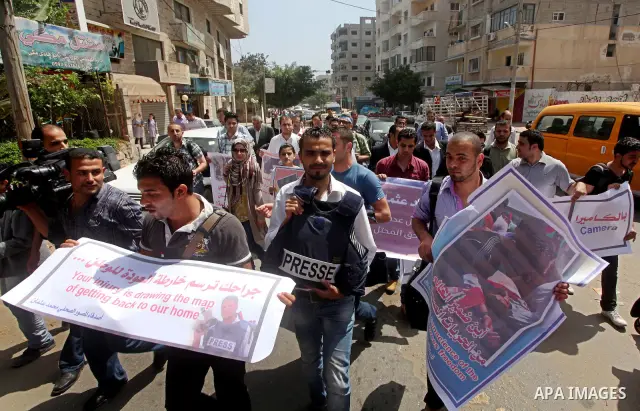 Palestinian journalists and photographers take part in a protest in support with the photographer, Mohammed Osman, in front of Palestinian Centre for Human Rights in Gaza city on May 16, 2012. Photo by Ashraf Amra