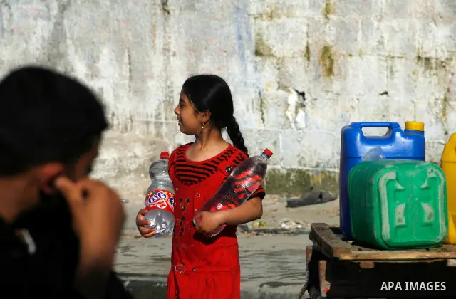 Palestinian children filling plastic bottles and jerry cans with drinking water from a public tap in the southern Gaza Strip refugee camp of Rafah on May 16, 2012. Photo by Eyad Al Baba