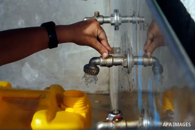 Palestinian children filling plastic bottles and jerry cans with drinking water from a public tap in the southern Gaza Strip refugee camp of Rafah on May 16, 2012. Photo by Eyad Al Baba
