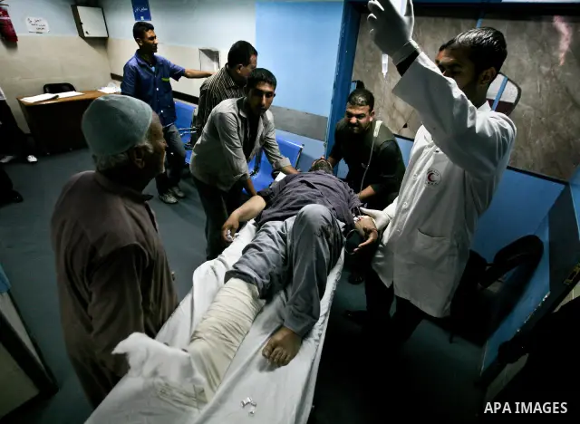 Palestinian medics receive a wounded man for treatment at a hospital in Gaza City on May 17, 2012, following Israeli shelling into the Gaza Strip in which seven people were wounded, two of them in critical condition, nea...
