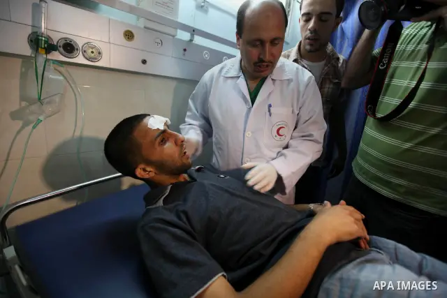 Palestinian medics receive a wounded man for treatment at a hospital in Gaza City on May 17, 2012, following Israeli shelling into the Gaza Strip in which seven people were wounded, two of them in critical condition, nea...