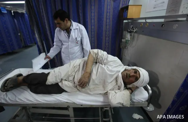 Palestinian medics receive a wounded man for treatment at a hospital in Gaza City on May 17, 2012, following Israeli shelling into the Gaza Strip in which seven people were wounded, two of them in critical condition, nea...