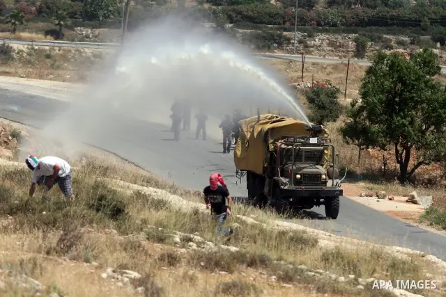 Israeli truck spray foul smelling water towards Palestinian protesters during a weekly demonstration in the West Bank, village of Nabi Saleh near Ramallah on Friday, May 18, 2012. Photo by Issam Rimawi