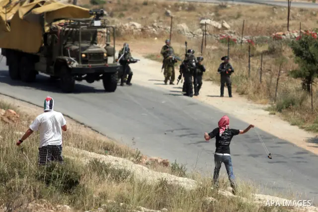 Palestinian protesters throw stones towards Israeli border police during a weekly demonstration in the West Bank, village of Nabi Saleh near Ramallah on Friday, May 18, 2012. Photo by Issam Rimawi