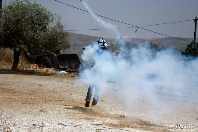Palestinian Protester returns a teargas towards Israeli soldiers during clashes in the northern West Bank village of Kufr Qaddum, near the Jewish settlement of Kdumim, Friday, May 18, 2012. Photo by Wagdi Eshtayah