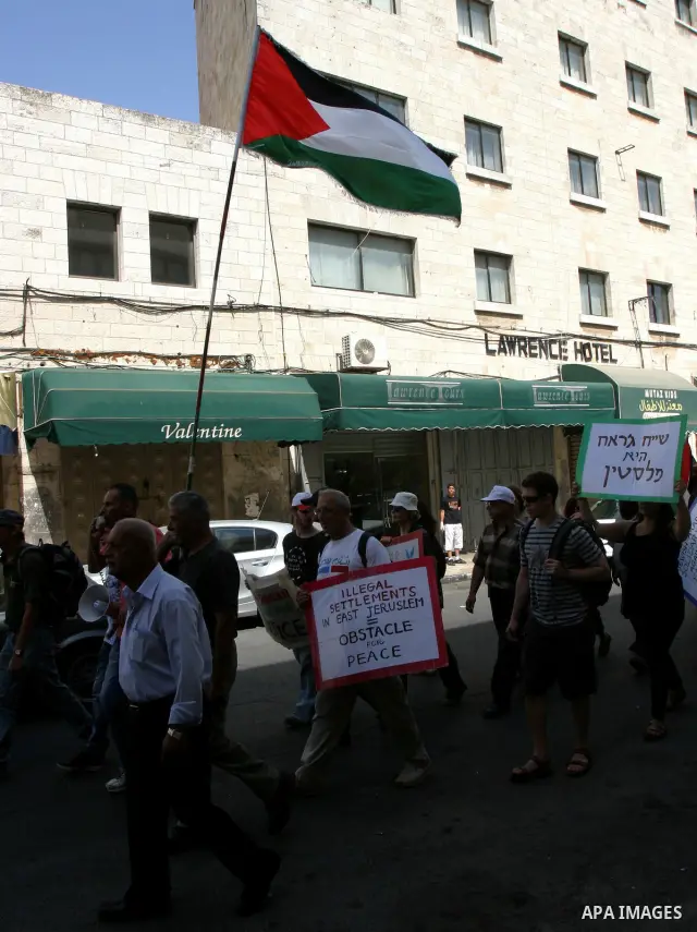 Palestinian and foreign activists hold Palestinian flags and slogans outside Damascus gate in Jerusalem's Old City, during a protest against land confiscation in the neighborhood of Sheikh Jarrah in the east Jerusalem on...