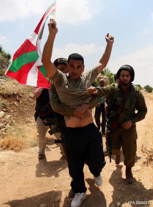 Palestinians wave their national flag during a demonstration a protest in Beit Amer village, north of the West Bank town of Hebron, on May 19, 2012 where Israeli soldiers tried to evacuate demonstrators by force and arre...