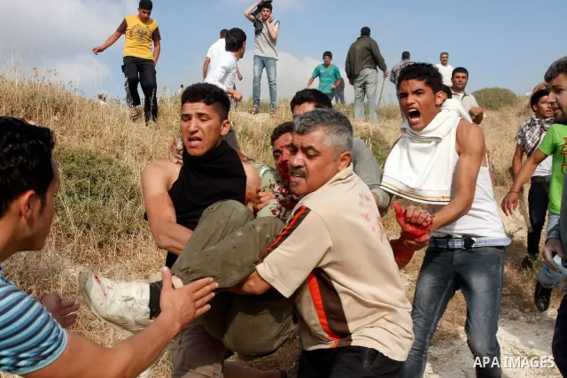 Palestinians carry an injured man, during clashes between Israeli settler from the Jewish settlement of Yitzhar and Palestinians from the village of Asira al-Qibiliya, south of the northern West Bank city of Nablus on Ma...