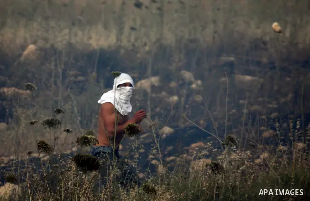Israeli settlers from the Jewish settlement of Yitzhar throw stones during clashes with Palestinians from the village of Asira al-Qibiliya, south of the northern West Bank city of Nablus on May 19, 2012. The Israeli army...
