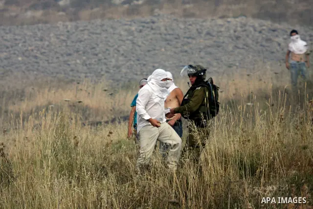 Israeli settlers from the Jewish settlement of Yitzhar throw stones during clashes with Palestinians from the village of Asira al-Qibiliya, south of the northern West Bank city of Nablus on May 19, 2012. The Israeli army...