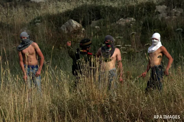 Israeli settlers from the Jewish settlement of Yitzhar throw stones during clashes with Palestinians from the village of Asira al-Qibiliya, south of the northern West Bank city of Nablus on May 19, 2012. The Israeli army...