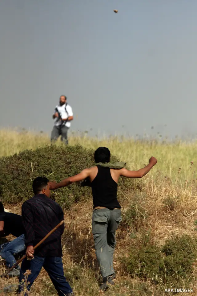A Palestinians man from the village of Asira al-Qibiliya throws stones during clashes with Israeli settlers from the Jewish settlement of Yitzhar, south of the northern West Bank city of Nablus on May 19, 2012. The Israe...