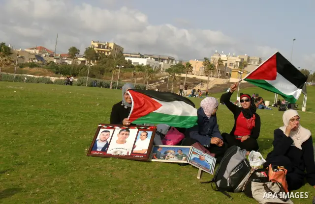 Families of Palestinian prisoners hold pictures of relatives held in an Israeli jail during tourist trip in the West Bank city of Jaffa, on May 19 2012. Photo by Mahfouz Abu Turk