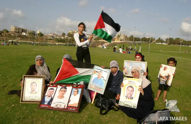 Families of Palestinian prisoners hold pictures of relatives held in an Israeli jail during tourist trip in the West Bank city of Jaffa, on May 19 2012. Photo by Mahfouz Abu Turk