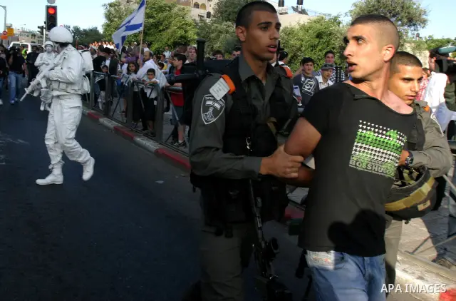 Israeli policemen detain a Palestinian demonstrator protesting against a parade marking Jerusalem Day in front of Damascus Gate outside Jerusalem's Old City on May 20, 2012. Israel occupied East Jerusalem in the 1967 Mid...
