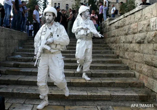 Israeli performance artists rest during a parade marking Jerusalem Day in Jerusalem's Old City May 20, 2012. Jerusalem Day marks the anniversary of Israel's capture of the Eastern part of the city during the 1967 Middle...