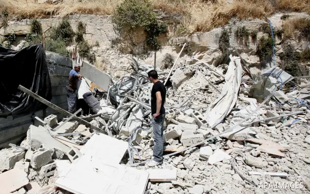 Palestinians survey the damage their house into the Jerusalem's old city on May 20, 2012. Thousands of Israelis marched into Jerusalem's old city to celebrate Jerusalem Day when the Jewish state captured the Arab eastern...