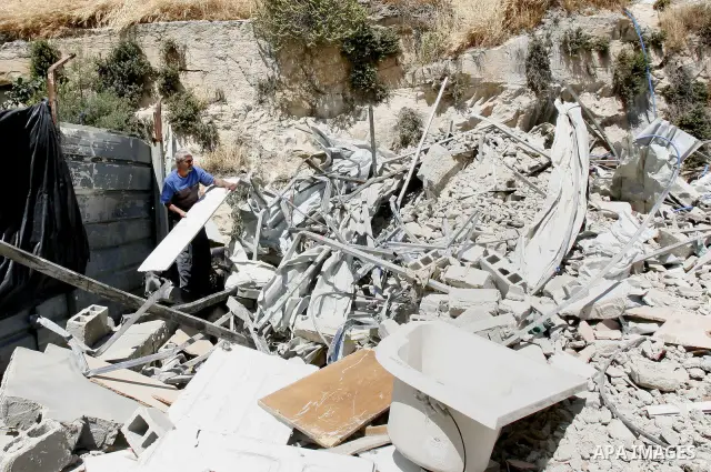 Palestinians survey the damage their house into the Jerusalem's old city on May 20, 2012. Thousands of Israelis marched into Jerusalem's old city to celebrate Jerusalem Day when the Jewish state captured the Arab eastern...