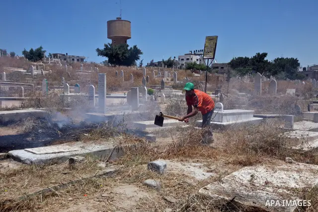 Palestinian prisoners in the prison run by the security forces in Gaza strip, work in a cemetery in Gaza City in activity to save enviroment. On May 21, 2012. Photo by Ali Jadallah
