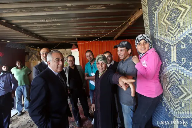 Palestinian Prime Minister Salam Fayyad, visits Om Rami Fatila's house in Tulkarm Governorate, in the West Bank on May 21, 2012. Photo by Mustafa Abu Dayeh