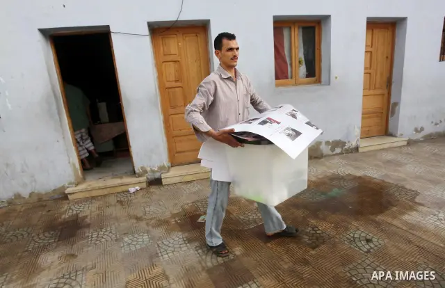 Egyptian workers carry empty ballot boxes to a polling station in the Coptic neighbourhood of Manshiyet Nasser in Cairo on May 22, 2012. A buzz of excitement swept through the Egyptian capital a day before its first pres...