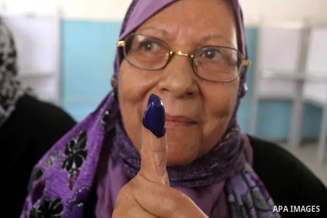 Egyptian woman shows her ink-marked finger after casting her ballot during the first round of Egypt's presidential elections, at a polling station in Cairo, Egypt, 23 May 2012. Egyptian voters, on 23 May, queued at polli...