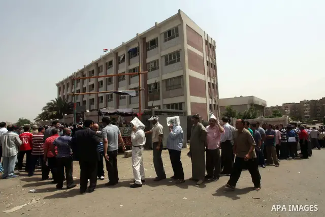 Hundreds of voters line up in front of one of the polling stations to cast their votes on the first day of the presidential elections in Cairo, Egypt, 23 May 2012. Egyptian voters, on 23 May, queued at polling stations f...