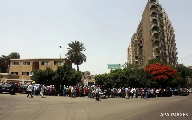 Hundreds of voters line up in front of one of the polling stations to cast their votes on the first day of the presidential elections in Cairo, Egypt, 23 May 2012. Egyptian voters, on 23 May, queued at polling stations f...