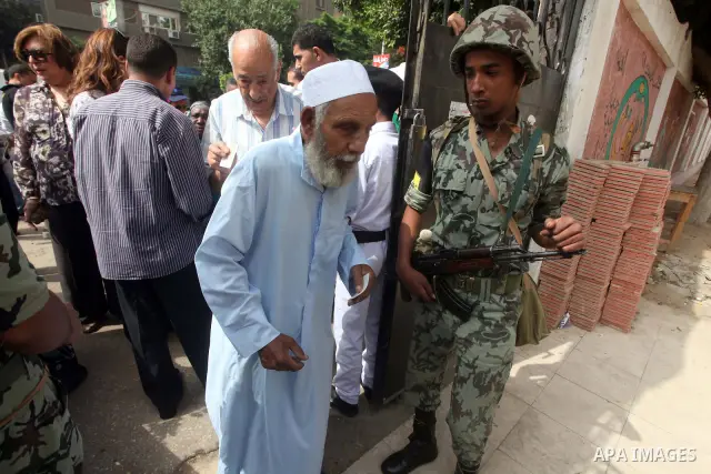 Hundreds of voters line up in front of one of the polling stations to cast their votes on the first day of the presidential elections in Cairo, Egypt, 23 May 2012. Egyptian voters, on 23 May, queued at polling stations f...