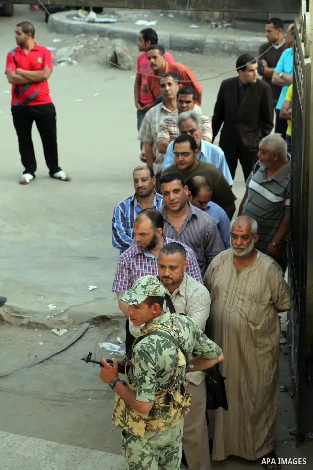 Hundreds of voters line up in front of one of the polling stations to cast their votes on the first day of the presidential elections in Cairo, Egypt, 23 May 2012. Egyptian voters, on 23 May, queued at polling stations f...