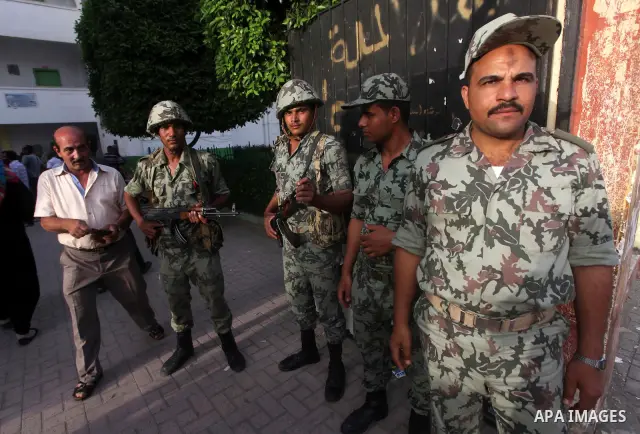 Egyptian security gards, stand in the front of one of the polling stations, on the first day of the presidential elections in Cairo, Egypt, 23 May 2012. Egyptian voters, on 23 May, queued at polling stations for the firs...