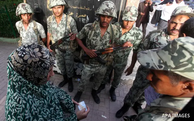 Hundreds of voters line up in front of one of the polling stations to cast their votes on the first day of the presidential elections in Cairo, Egypt, 23 May 2012. Egyptian voters, on 23 May, queued at polling stations f...