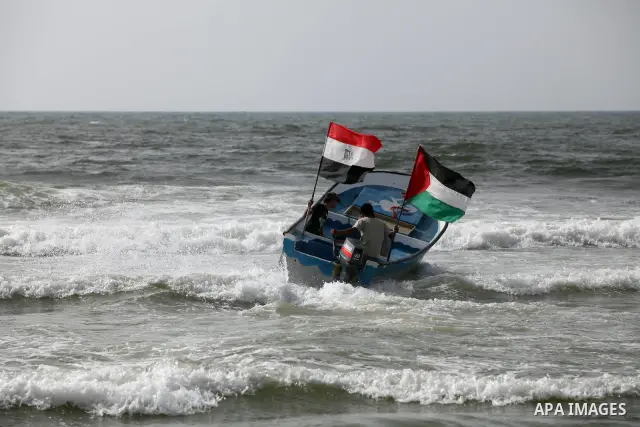 Palestinian holds a Palestinian and Egyptian flags on his boat at the beach of Gaza city on 24 May 2012, in the first Egyptian Presidential election since the ouster of former president Hosni Mubarak in February 2011. Ph...